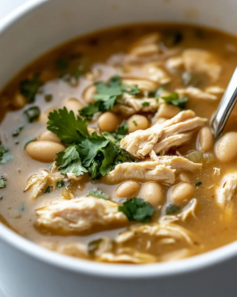 Bowl of creamy white chicken chili topped with cilantro and avocado